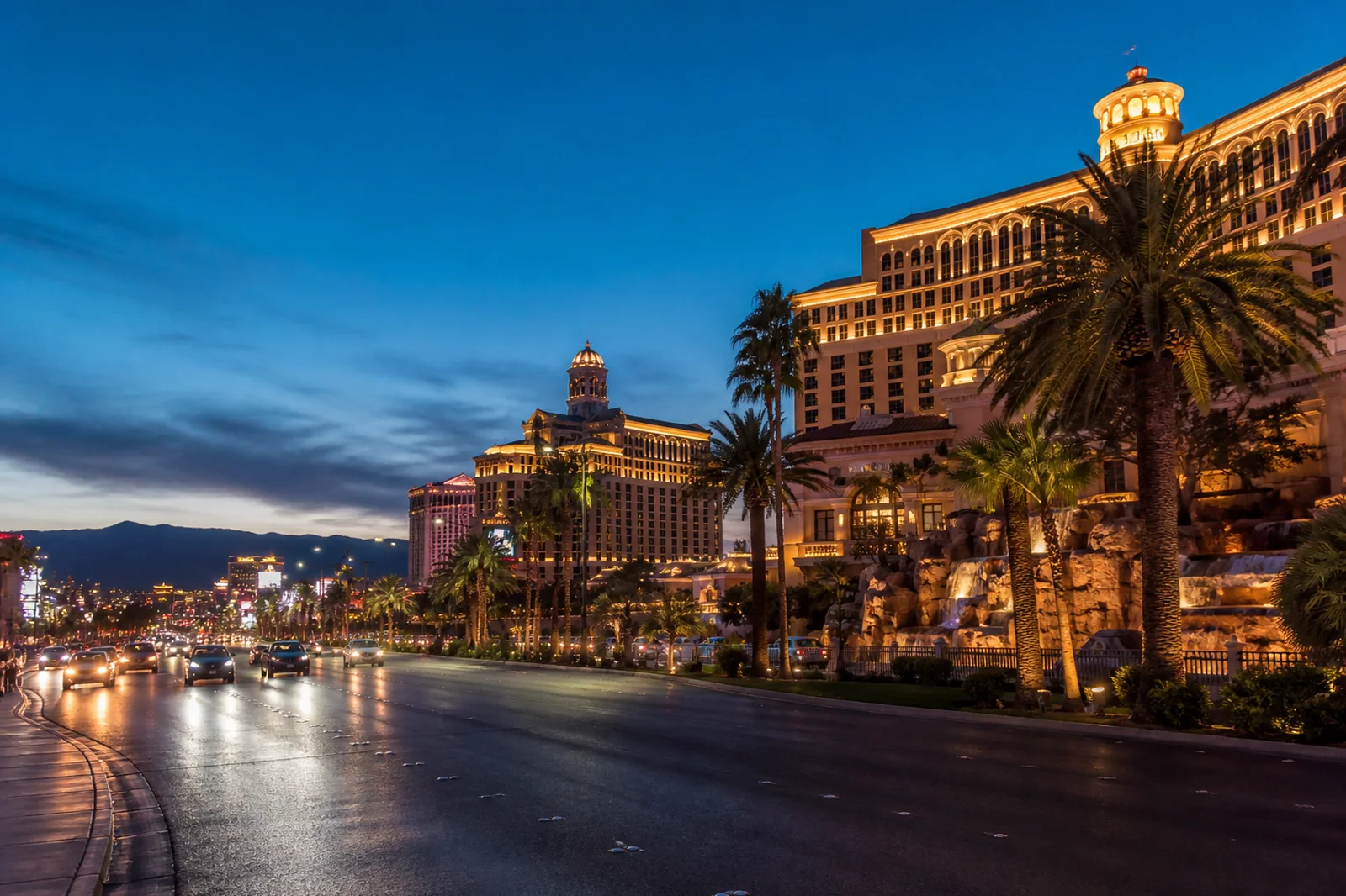 Las Vegas Strip skyline glowing at blue hour with desert mountains beyond