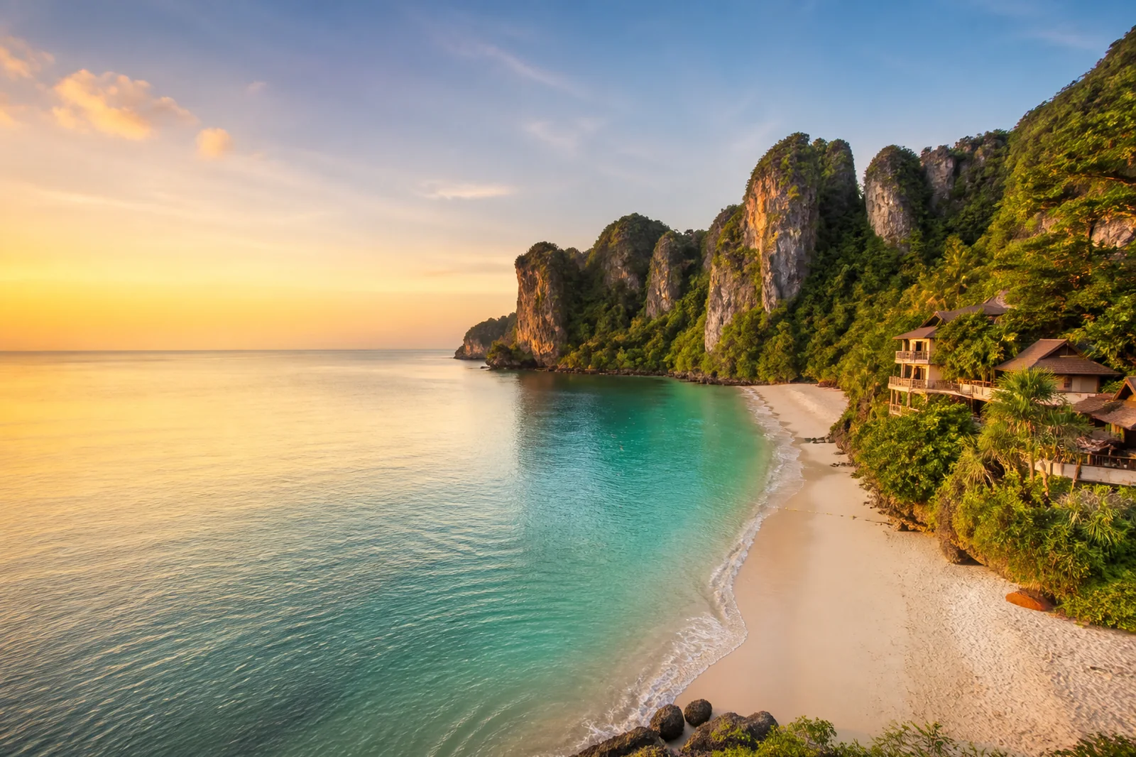 Phuket tropical bay with clear Andaman water, limestone headland and long-tail boat