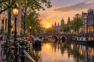 Amsterdam canal at sunset with canal houses, an arched bridge and bicycles