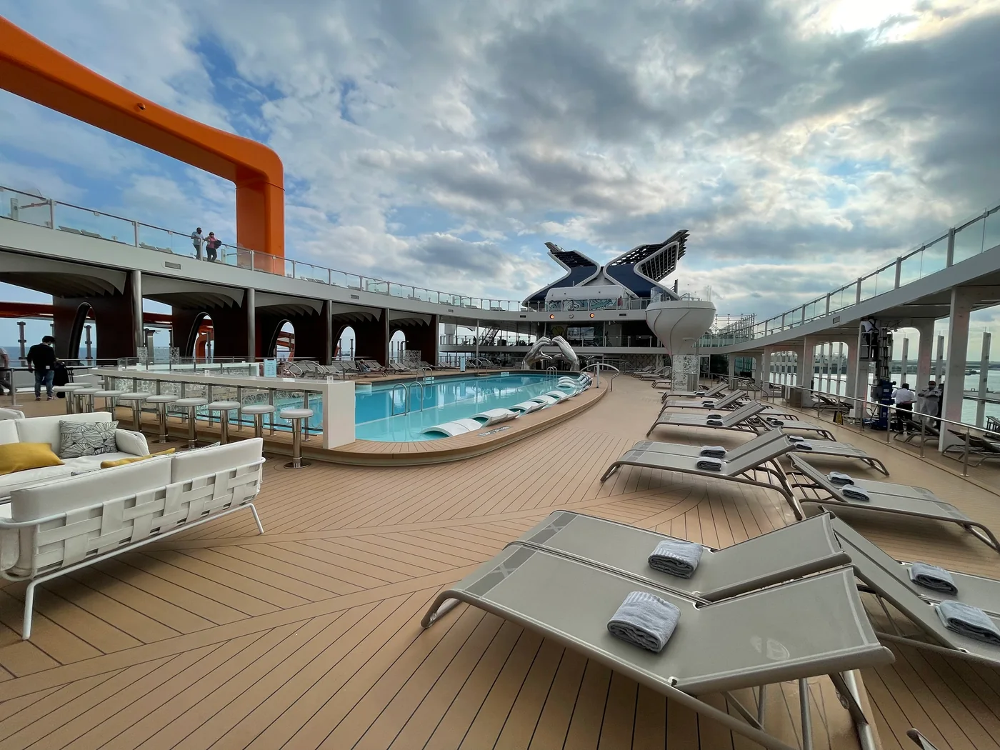 Outdoor swimming pool and sun loungers aboard Celebrity Apex